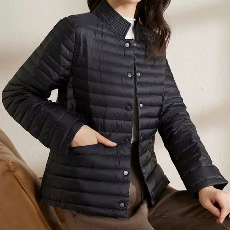 Person wearing a black puffer jacket against a neutral background