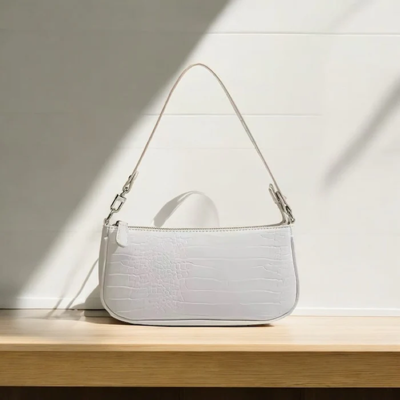 White handbag on a wooden surface with a light background