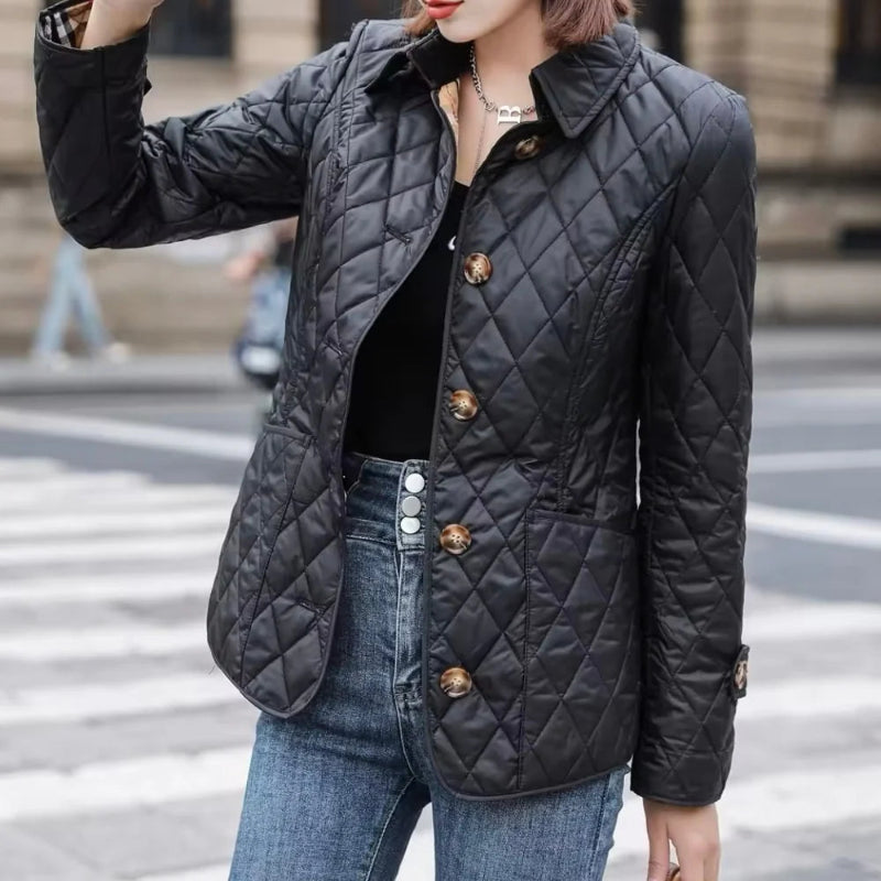 Person wearing a black quilted jacket on a city street