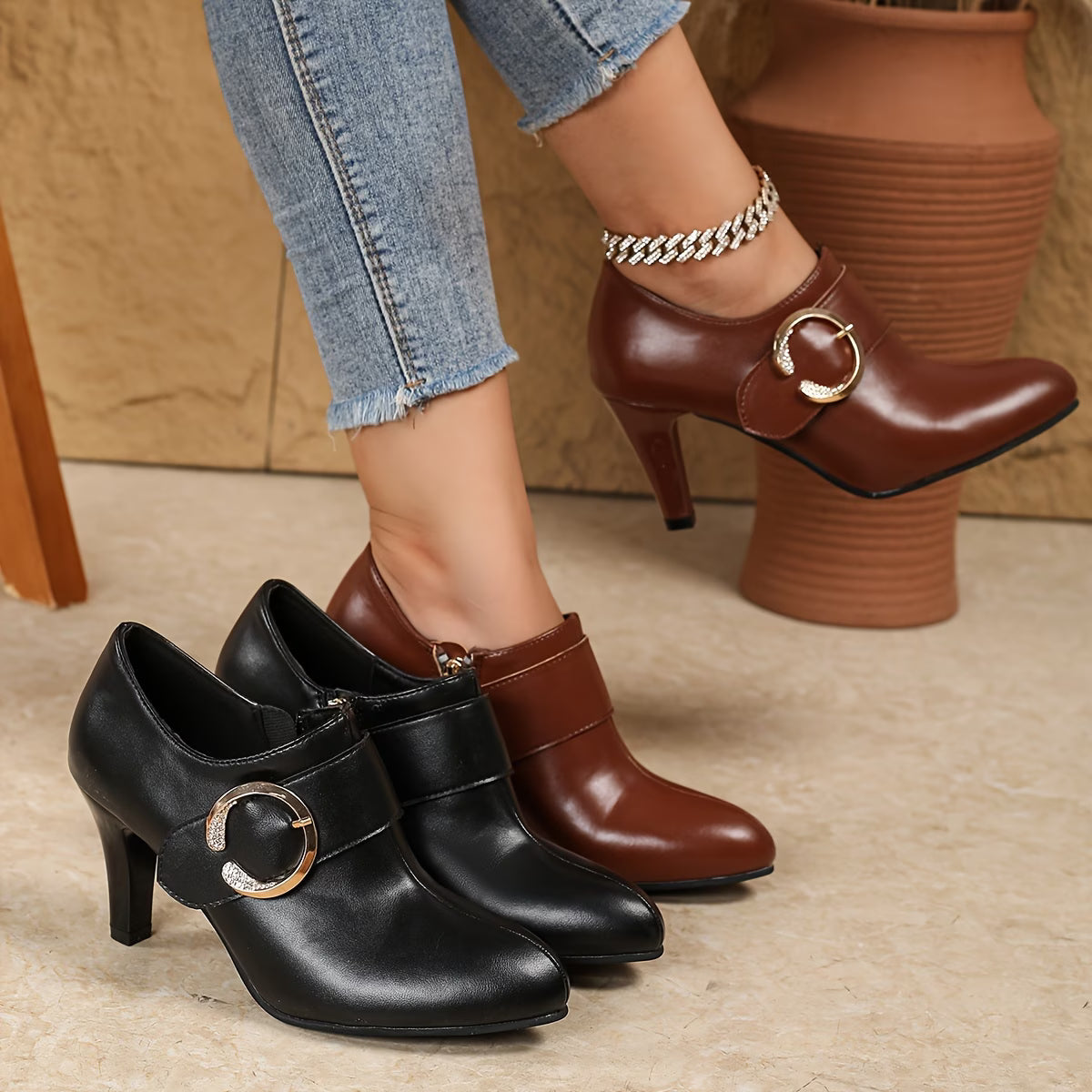 Black and brown high-heeled shoes with gold buckles on a neutral background