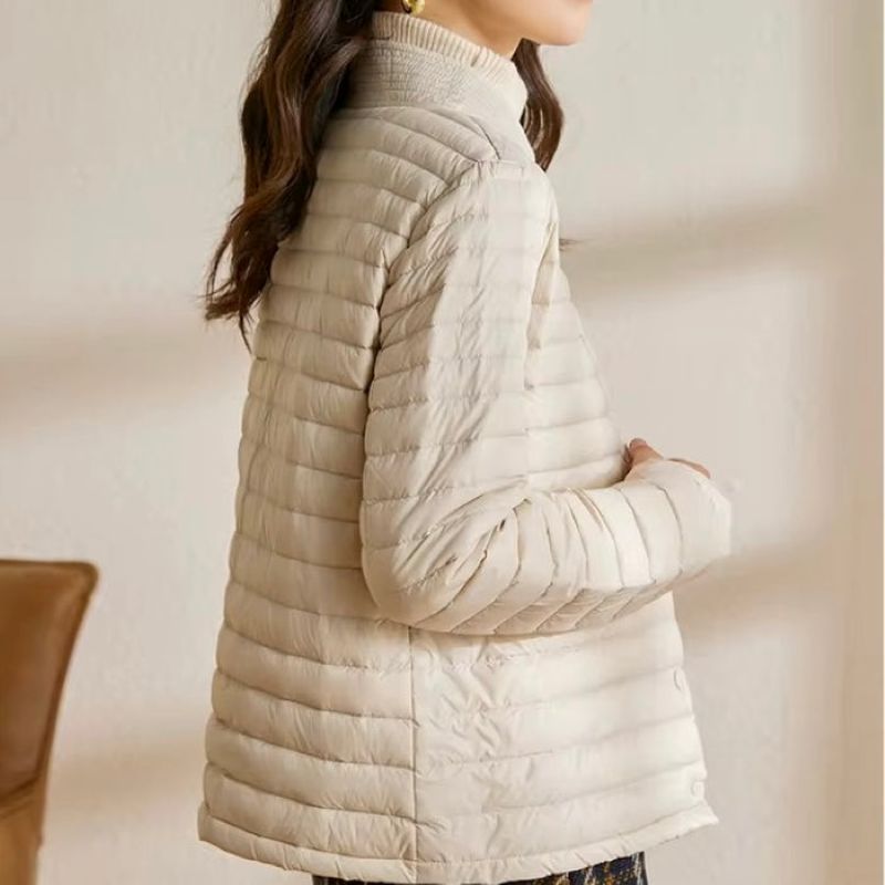 Beige puffer jacket worn by a person against a neutral background
