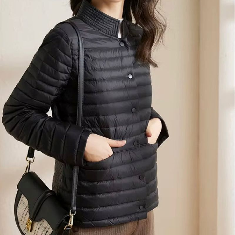 Person wearing a black puffer jacket with a neutral background