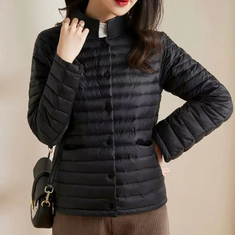 Person wearing a black puffer jacket with a neutral background
