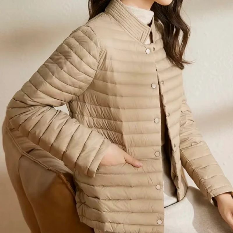 Beige quilted jacket worn by a person on a neutral background