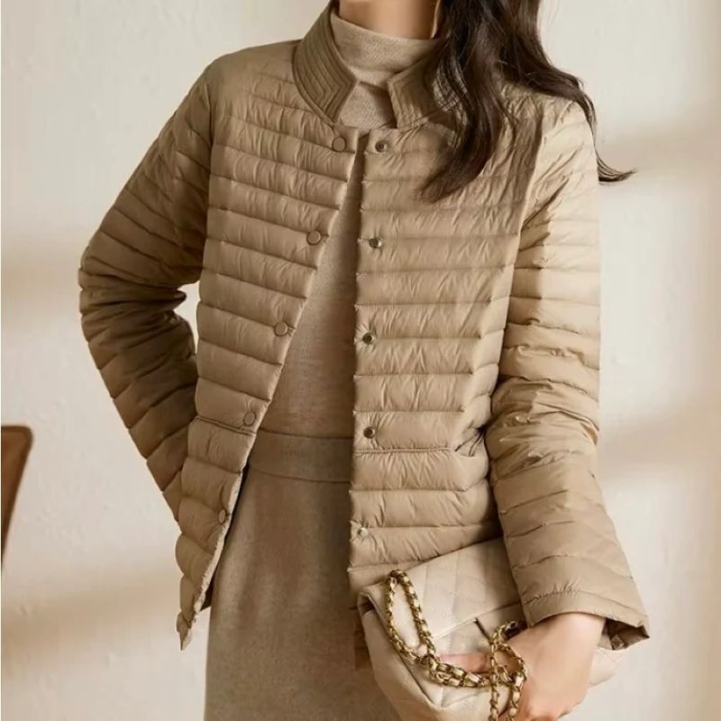 Beige quilted jacket worn by a person with a neutral background