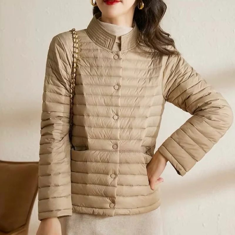 Beige puffer jacket worn by a person on a neutral background