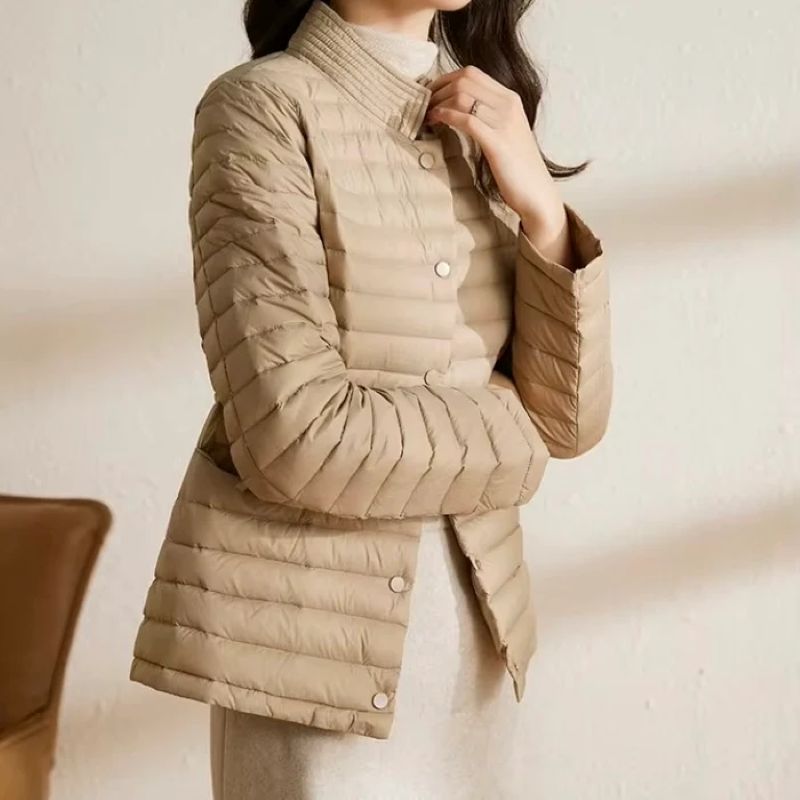 Beige quilted jacket worn by a person against a neutral background