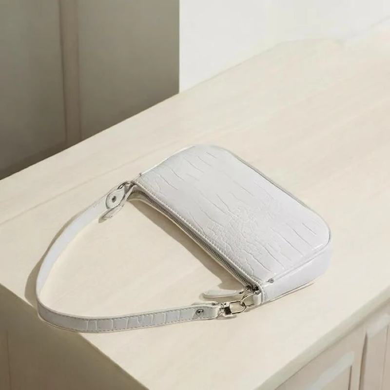 White handbag with a strap on a light surface