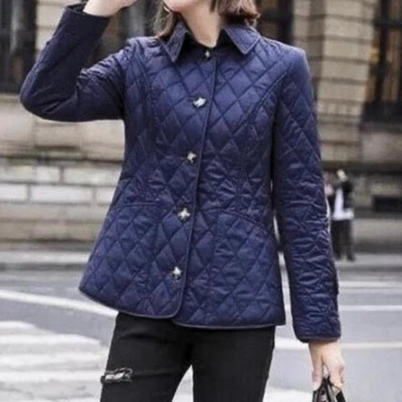 Person wearing a blue quilted jacket on a city street