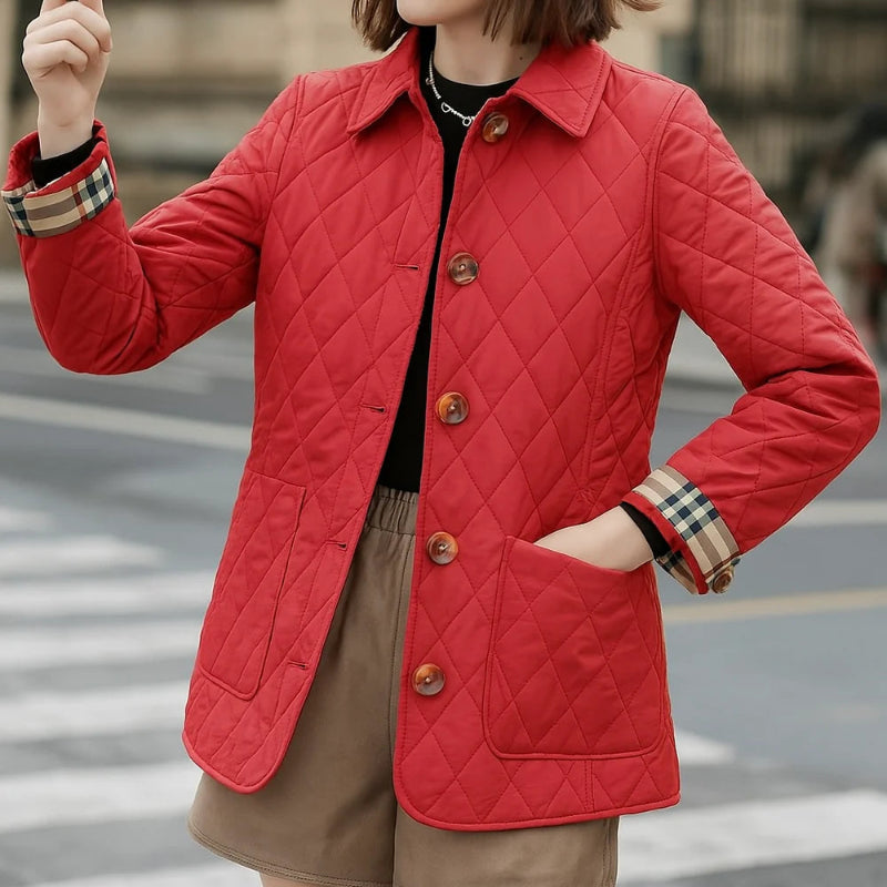 Person wearing a red quilted jacket with a blurred street background