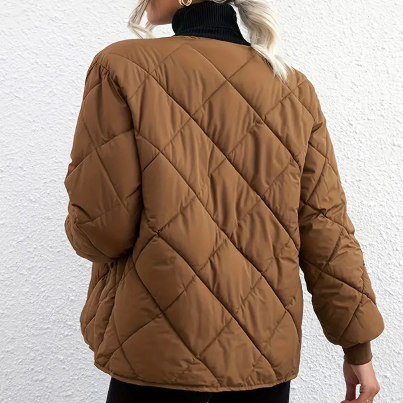 Brown quilted jacket worn by a person on a white background