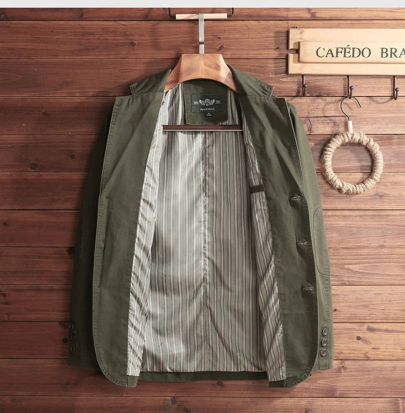 Green jacket with striped shirt on a wooden hanger against a wooden wall with 'CAFÓDO' sign.