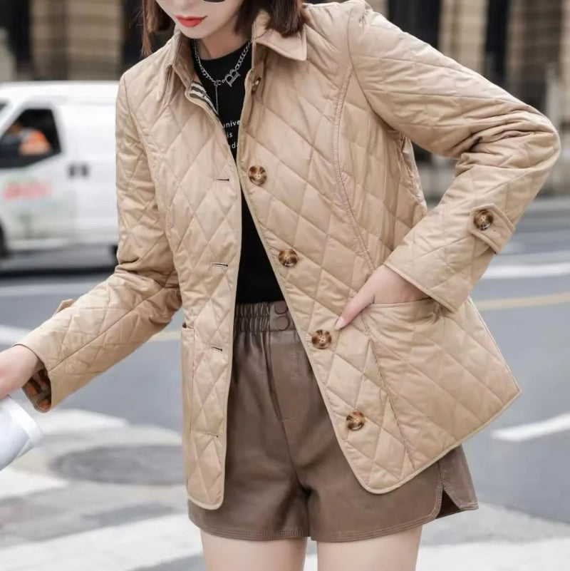Person wearing a beige quilted jacket on a city street