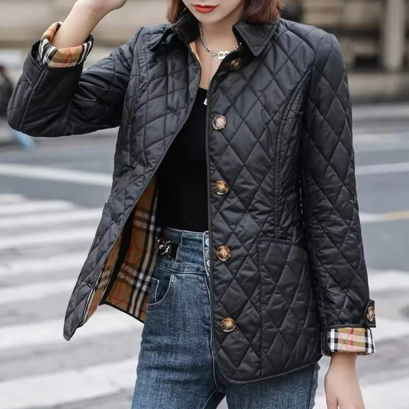 Person wearing a black quilted jacket with a blurred city 